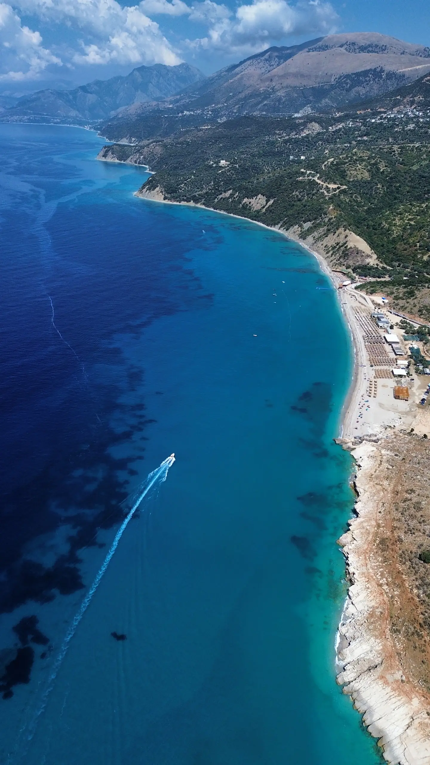 Aerial view of a speed boat cruising the Lukove beach.