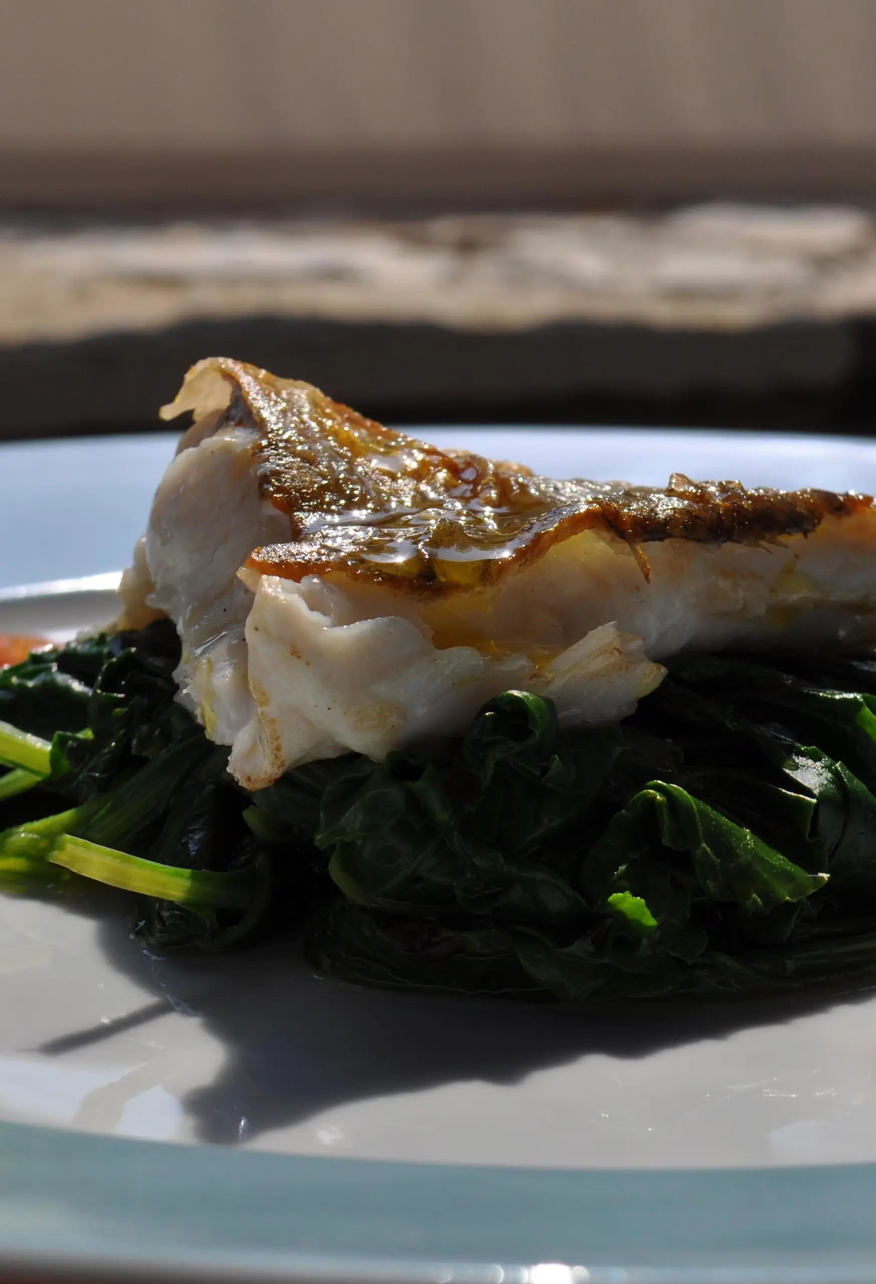 Boiled wild greens served with fresh fried fish.